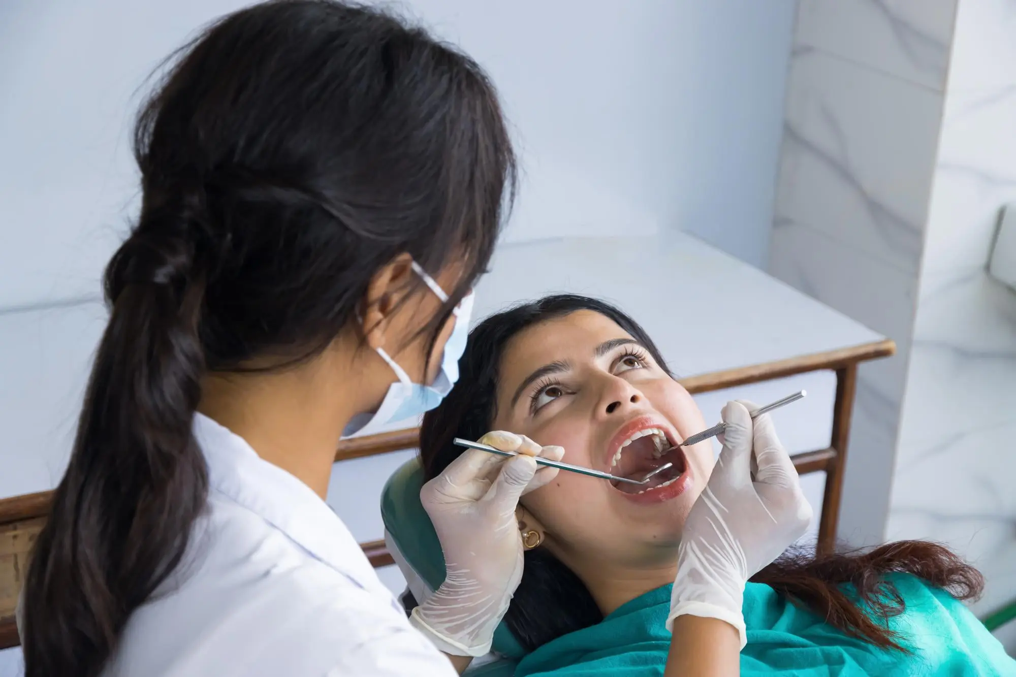 At Sweet Smiles Orthodontics in Arlington MA, a dentist checks a patient's mouth with dental tools for oral habits or Tongue Thrust.