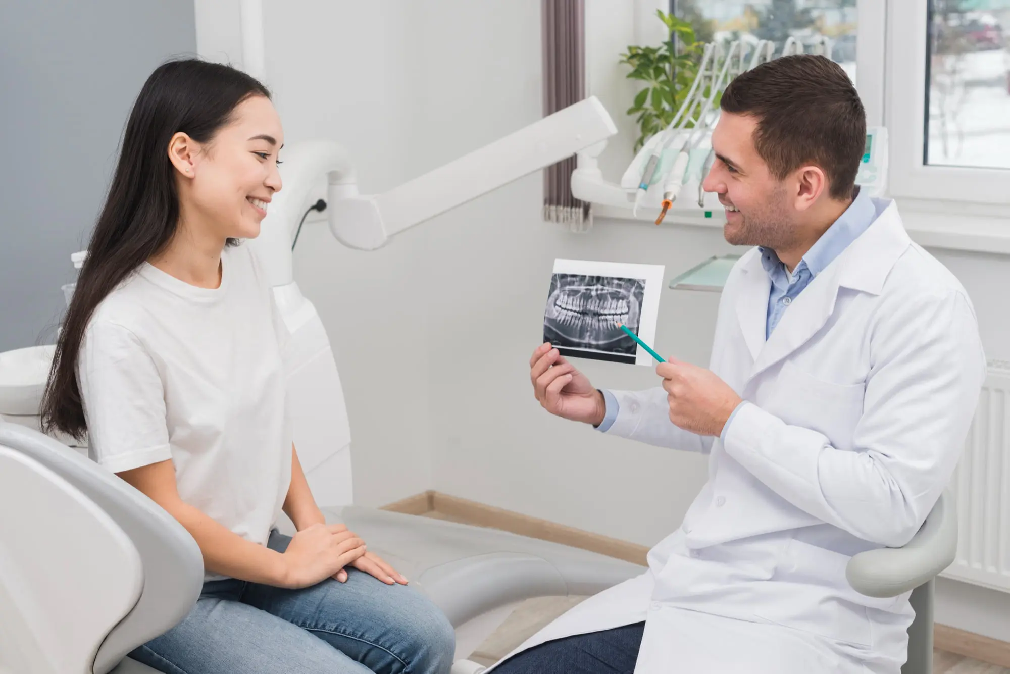 At Sweet Smiles Orthodontics in Arlington, MA, a dentist shows a dental X-ray for dental care with metal braces for patient in the chair.