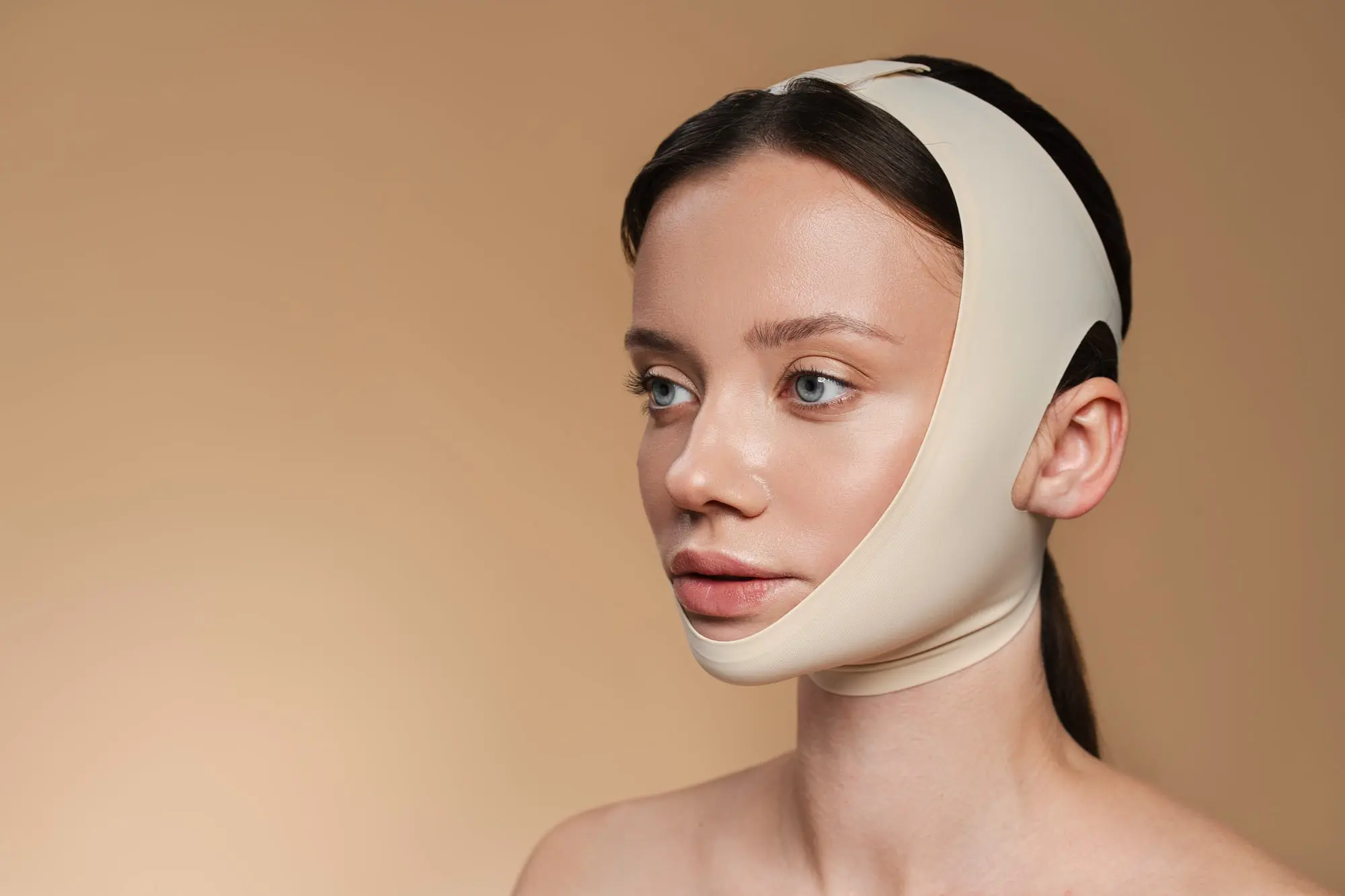 A woman with a face mask on her head, awaiting jaw surgery at Sweet Smiles Orthodontics in Arlington, MA