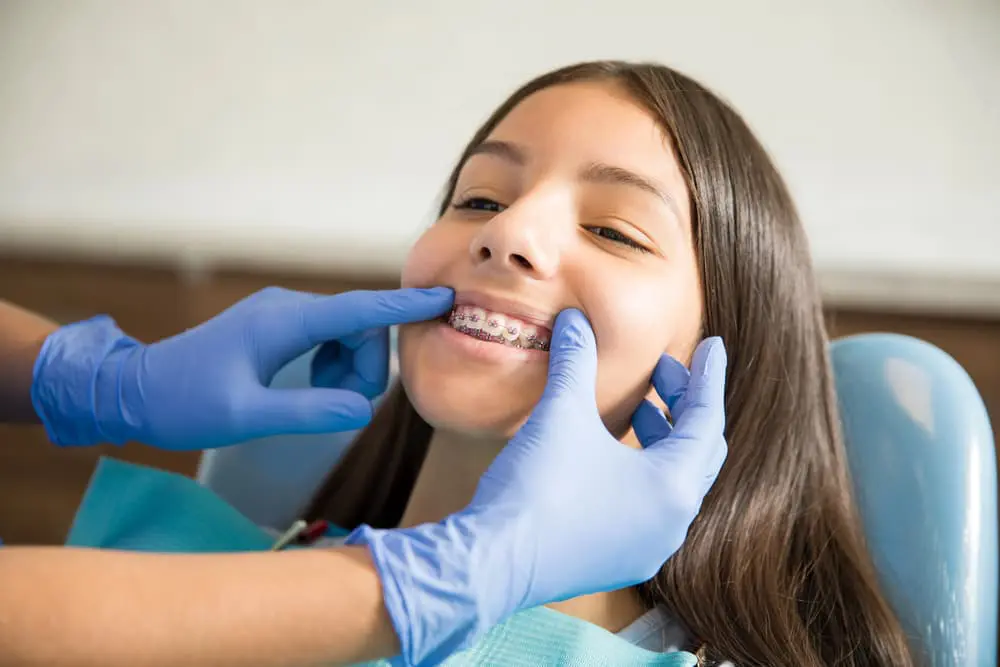 Child orthodontic patient having metal braces examined by
Children’s Orthodontist at Sweet Smiles Orthodontics in Arlington MA, showing routine pediatric orthodontic appointment care
