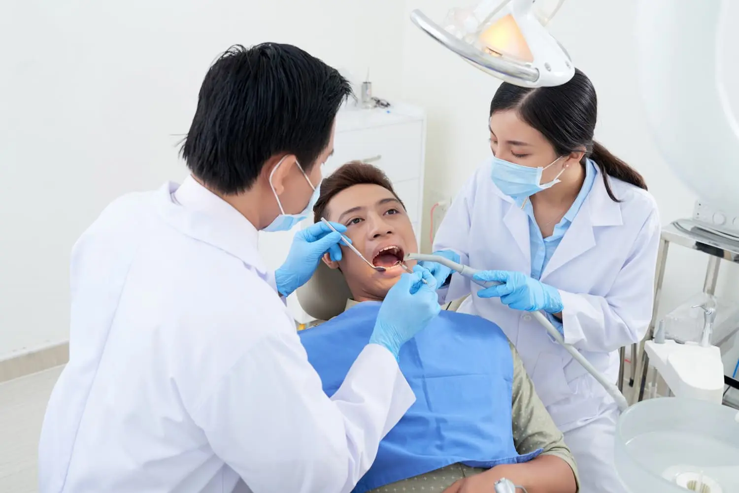 Orthodontic team performs comprehensive tongue thrust examination and treatment planning, with doctor and assistant evaluating patient's oral function and tongue positioning using specialized instruments at Sweet Smiles Orthodontics in Arlington, MA