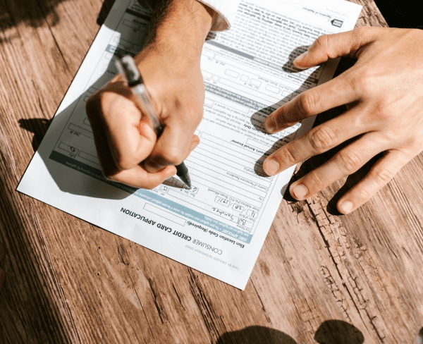 Filling out a credit card application, a person considers Invisalign Insurance at Sweet Smiles Orthodontics in Arlington, MA.