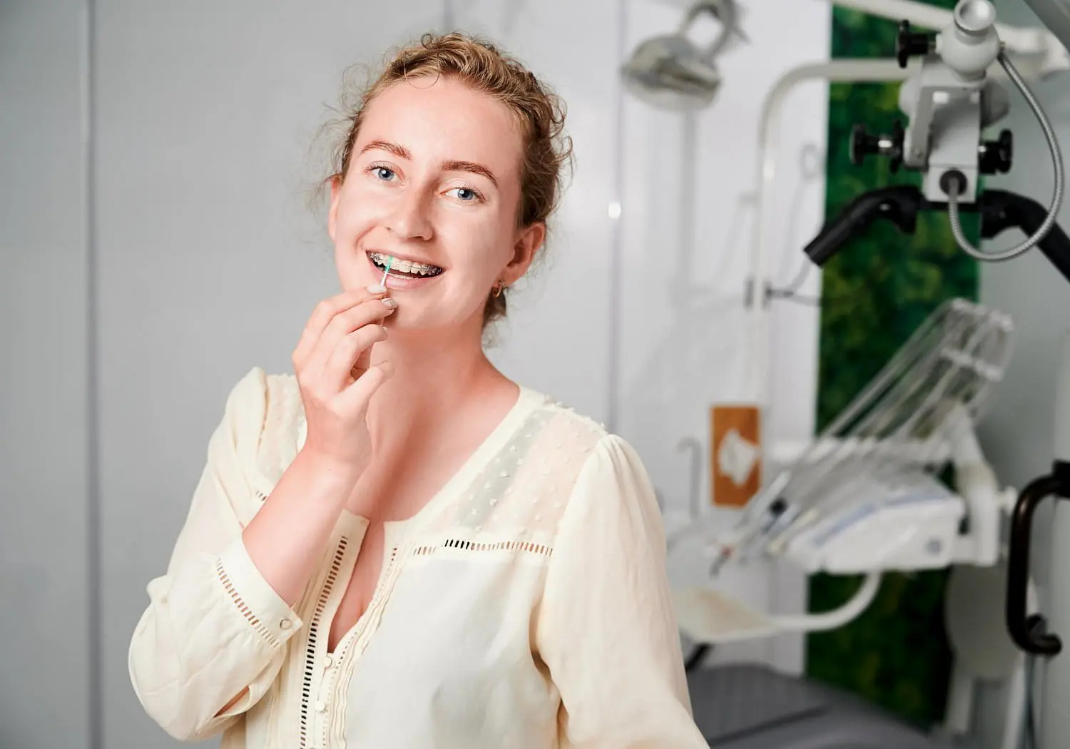 At Sweet Smiles Orthodontics in Arlington, MA, a young woman smiles at the camera with clear ceramic braces.