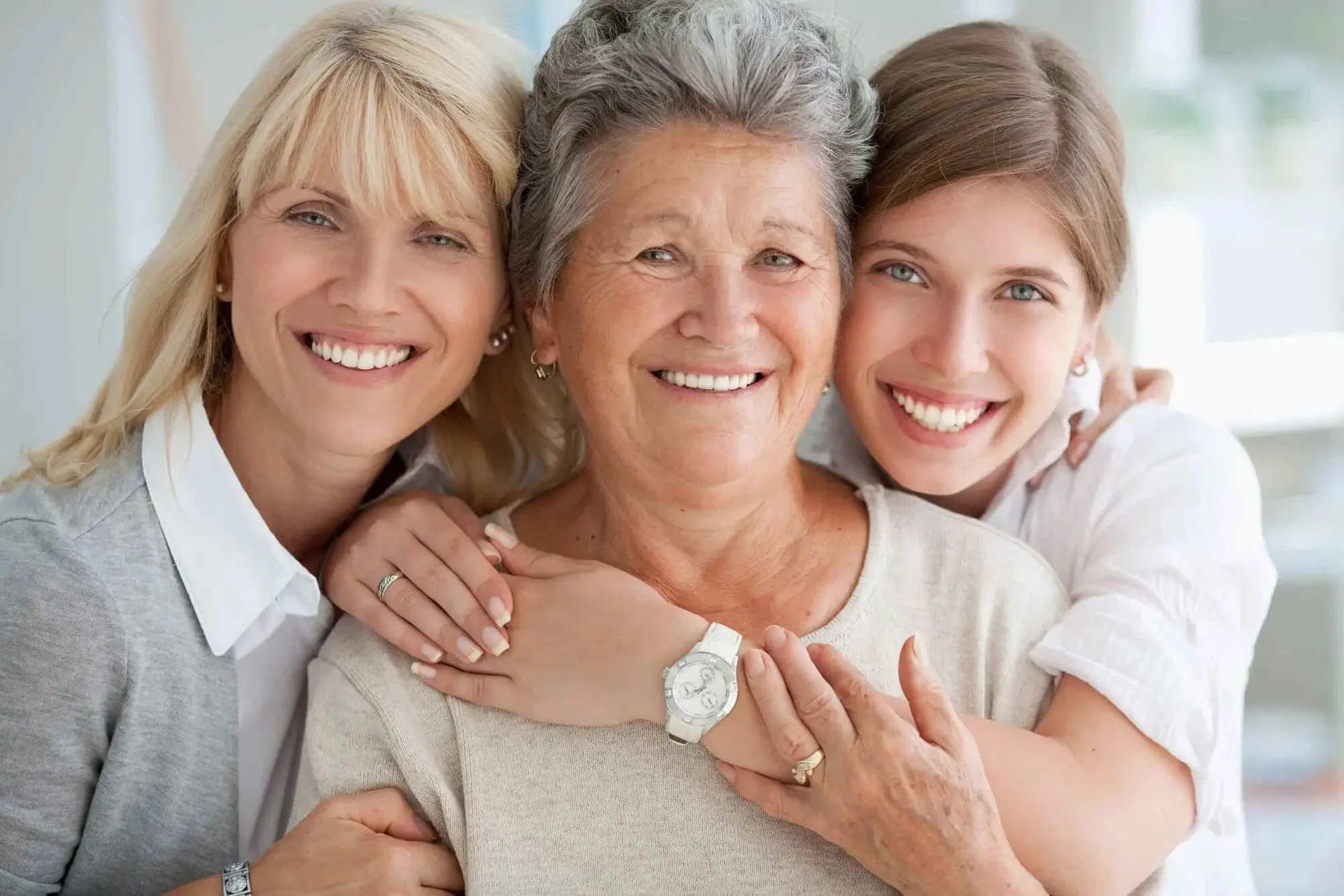 Smiling women of various ages pose together indoors, showing confidence with treatment by Adult Orthodontics from Sweet Smiles Orthodontics in Arlington, MA.