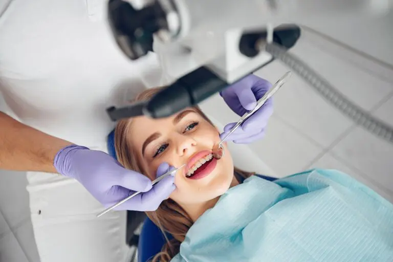 At Sweet Smiles Orthodontics in Arlington, MA, a dentist in purple gloves examines a relaxed patient for possible braces glue removal - How To Get Braces Glue Off Teeth in Arlington, MA